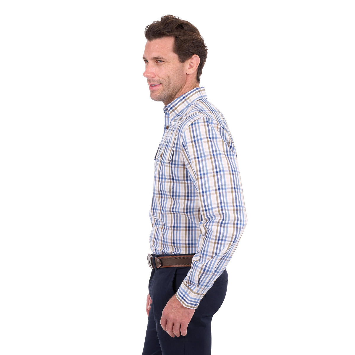 A man shown in profile wearing a long-sleeve button-down plaid shirt with blue, white, and tan stripes, paired with dark trousers and a brown belt, against a plain white background.