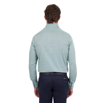 A man viewed from the back wearing a light sage green long-sleeve dress shirt with a subtle micro-pattern, paired with navy trousers and a black belt, against a plain white background.