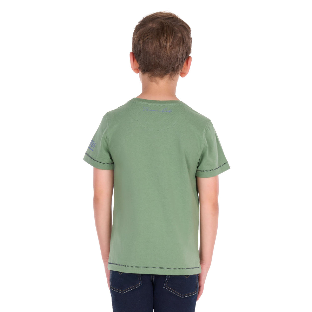 A child viewed from behind wearing a sage green short-sleeve t-shirt with dark blue jeans, set against a plain white background.