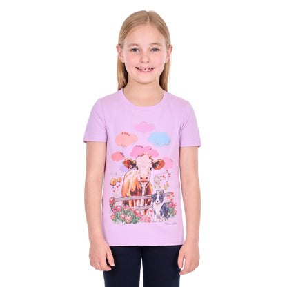A young girl with blonde hair wearing a light purple short-sleeve t-shirt with a colorful graphic of a cow, flowers, and clouds, paired with dark pants, against a plain white background.